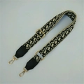 Detail of adjustable woven wide shoulder strap with jacquard pattern and gold metal buckles - Black Rice Pattern + Black Leather