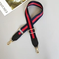 Detail of red and blue striped adjustable nylon bag strap with gold metal swivel clasps - Blue/Red/Blue With Black Leather