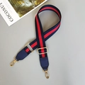 Close-up of adjustable striped canvas strap with navy leather and gold hardware - Blue/Red/Blue With Blue Leather