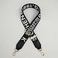 Detail eines verstellbaren schwarzen Web-Schultergurts mit weißer Schrift und Goldclips - Schwarz