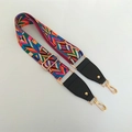 Detail of adjustable woven guitar-style bag strap with ethnic geometric patterns and gold hooks - Rainbow