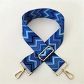 Close-up of adjustable woven chevron strap with gold-tone metal buckles in blue and black - Blue Pattern Gold Buckle