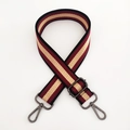 Détail d'une bandoulière en toile rayée rouge, beige et noire avec crochets foncés - Rouge Vin Boucle Bronze à Canon
