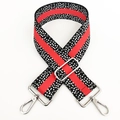 Detail of red and black polka dot pattern on adjustable canvas bag shoulder strap - Black Orange Silver Buckle