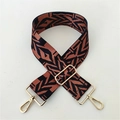 Close-up of wide adjustable woven bag strap with orange and black geometric pattern - Black Brown Pattern Gold Buckle