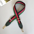 Close-up of adjustable striped canvas strap with green leather and gold metal hooks - Black/Red/Green With Green Leather