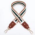 Close-up of adjustable striped canvas bag strap with leather ends and gold hardware - Brown + Brown Leather