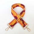 Detailansicht des gewellten Taschengurt-Designs mit goldenen Karabinerverschlüssen - Orange