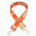 Close-up of colorful geometric woven bag strap with golden metal lobster clasps - Orange Khaki