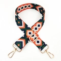 Close-up of ethnic geometric weaving pattern and gold metal hook on adjustable bag strap - Orange Green