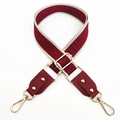 Detail of red-brown woven bag strap with geometric patterns and gold metal lobster clasps - Wine Red