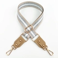 Detail view of beige bag strap with silver metallic stripes and gold lobster clasps - Khaki