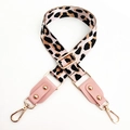 Close-up of leopard print bag strap with pink leather trim and gold metal hooks - Pink + Pink Leather
