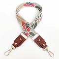 Macro detail of colorful floral jacquard pattern bag strap with gold metal hooks - Brown