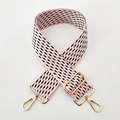 Detailansicht des rosa-schwarz gemusterten Taschenriemens mit goldenen Metallbeschlägen - Rosa