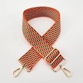 Detail of adjustable 5cm wide jacquard embroidered bag strap with golden metal swivel hooks - Orange