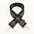 Close-up of wide geometric pattern shoulder strap with gold metal hooks and adjustable buckle - Black Base Dark Grey Diamond / Silver Clasp