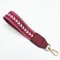 Macro detail of burgundy woven strap with white V-pattern and gold swivel hook clasp - Silver Clasp / Burgundy