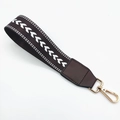 Close-up of woven dark brown wrist strap with heart pattern and gold swivel clasp - Brown
