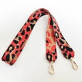 Detail eines breiten Schultergurts mit rotem Leopardenmuster und goldenen Karabinerhaken - Langer Stil / Orange