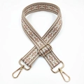 Close-up of geometric jacquard embroidered bag strap with golden metal hardware - Khaki Base Pink