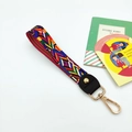 Colorful geometric woven wrist strap with gold lobster clasp and black leather detail - Rainbow
