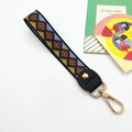 Detailed close-up of geometric woven wrist strap with premium leather and gold lobster clasp - Argyle