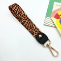 Macro detail of classic leopard print fabric wrist strap with gold metal lobster clasp - Leopard Print