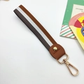 Detail of striped woven wrist strap with premium leather connector and gold lobster clasp - Brown-White-Grey