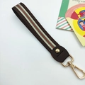 Detail of red and green striped web strap with brown leather and gold metal carabiner - Retro Coffee Stripes