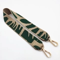 Close-up of bohemian woven bag strap with green leaf pattern and gold metal lobster clasps - Dark Green Elephant