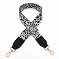 Close-up of leopard print canvas bag strap with gold metal hooks and black leather ends - White Purple Leopard