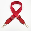 Detail of adjustable bright red nylon bag strap with gold rotating hooks on white background - Red / Gold Buckle