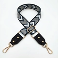 Detail of adjustable bag strap with black and white chevron pattern and gold metal hooks - Silver Clasp / Black and White Geometric/Black Leather