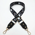 Detail of floral embroidered bag strap with golden rivets and adjustable metal buckles - Black White Flower + Black Leather