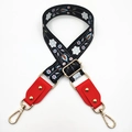 Close-up of ethnic floral embroidery bag strap with red leather ends and gold studs - Black White Flower + Red Leather