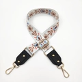 Detail of bohemian wide bag strap with colorful floral embroidery and gold metal rivets - White & Brown Flowers + Black Leather