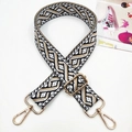 Close-up of geometric jacquard bag strap with gold metal lobster hooks and adjustable buckle - Black