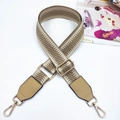 Detail eines verstellbaren gewebten Tragegurts mit Goldhaken und Lederbesatz - Goldschnalle / Dunkelbeige