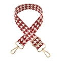 Macro detail of red and white houndstooth bag strap with adjustable gold lobster buckles - Brick Red