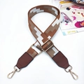 Close-up of geometric pattern bag strap with brown leather and gold metal clips - Ladder Grid Brown