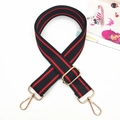 Dettaglio tracolla regolabile in nylon nero con strisce rosse e ganci in metallo dorato - Fibbia Oro / Nero Rosso