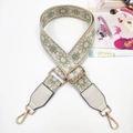 Detail of green floral woven bag strap with golden metal hooks and leather ends - Gold Buckle / Matcha Green And White