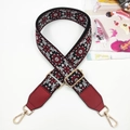 Close-up of ethnic floral embroidery on a wide bag strap with gold metal swivels - Gunmetal Buckle / Wine Red