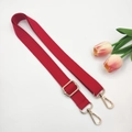 Detail of red cotton canvas strap with gold metal hooks and adjustable buckle on white background - Red