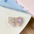 Top view of a bow-shaped resin phone grip tok with colorful glitter heart sequins - Multi-color Sugar Heart (Large Bow Stand)