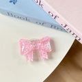 Close-up of pink glitter bow phone grip with sparkly sequins on a white desk - Pink Sugar Heart (Large Bow Stand)