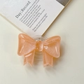 Dettaglio del supporto Griptok a fiocco pesca con glitter dorati e resina lucida - Supporto a Fiocco Grande - Arancione Bagliore di Nuvola
