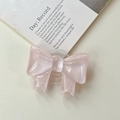 Close-up of pink glitter bow phone grip with transparent expanding stand on magazine - Large Bow Stand - Cloud Flash Pink