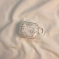 Dettaglio custodia AirPods Pro glitterata con fiocchi di perle e gancio tondo - Fiocco Glitterato Con Anello Bianco / AirPods 1ª/2ª generazione